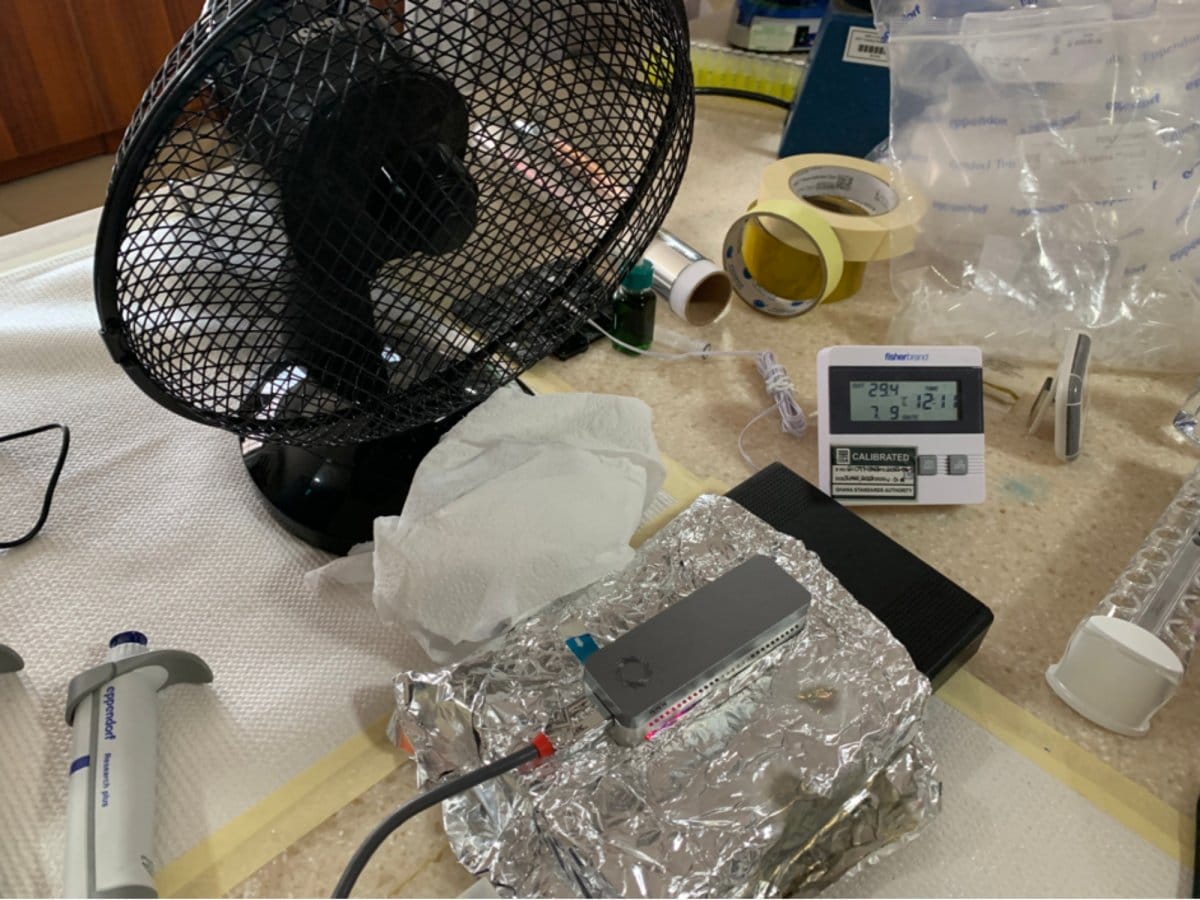Challenges with temperature regulation in Navrongo – indoor temperatures frequently over 30°C made it difficult to maintain optimal MinION temperatures for sequencing. Picture shows the team's setup with a fan blowing over an ice pack, with the MinION on aluminium foil. (Credit: William Hamilton)